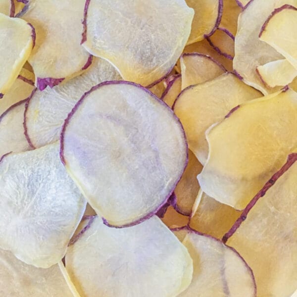 pile of dehydrated potato slices with red peel visible