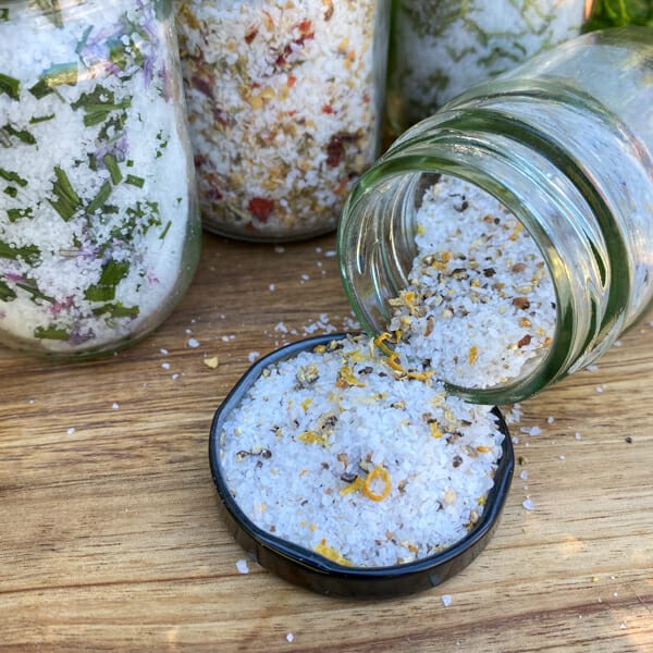 Lemon pepper finishing salt poured out of the jar in the lid with other flavours in the background.