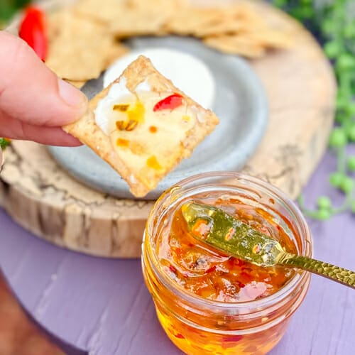 hot pepper jelly served on a cracker with creamy cheese
