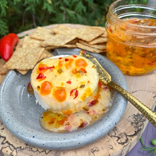 hot pepper jelly poured over creamy brie with crackers served on the side