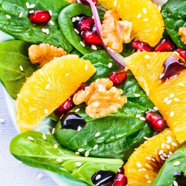 orange and pomegranates on spinach close up