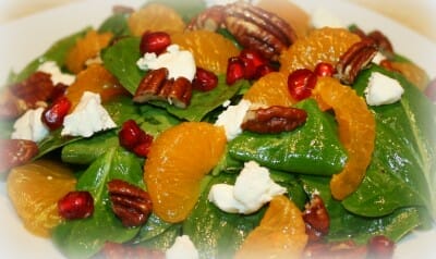 mandarin oranges, pomegranates and cheese on spinach