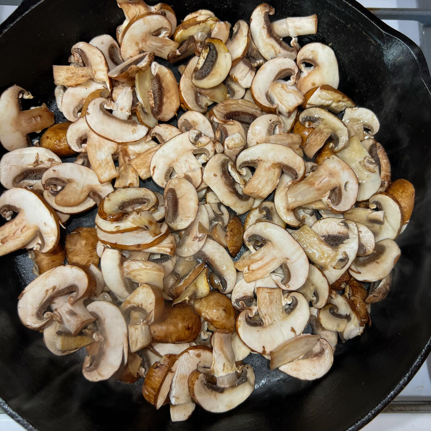 fry pan with raw sliced mushrooms