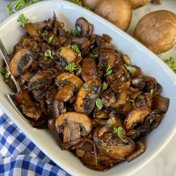 serving plate with sauteed mushroom and onions with green thyme bits
