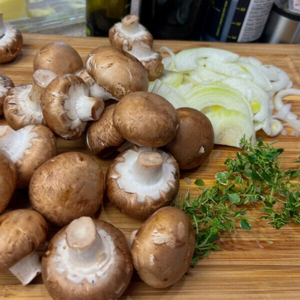 ingredients for recipe on cutting board lots of mushrooms
