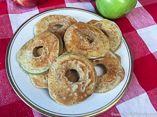 Baked apple pancake rings served on a round plate.