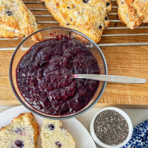 blueberry strawberry chia seed jam in glass dish with biscuits
