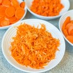 bowl of blanched shredded carrots other carrot bowls behind