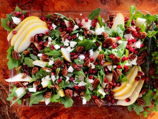 pear and arugula with pomegranates, pecans and feta on platter