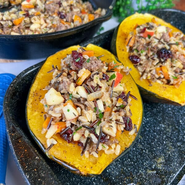 acorn squash with stuffing in roasting pan
