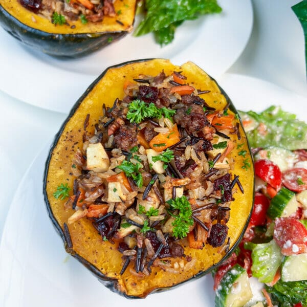 stuffed acorn squash on plate with salad ready to eat