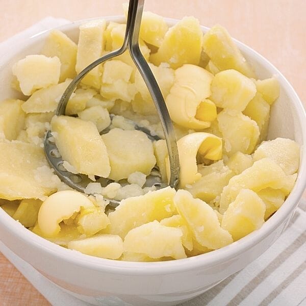 butter in mashed potatoes with masher
