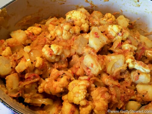 mixing cauliflower potato curry