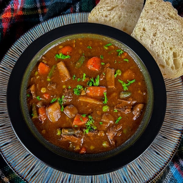 beef stew in bowl on plate with bread