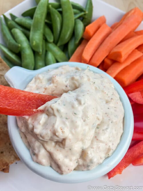 Onion soup mix sour cream dip with sliced carrots, peppers, snap peas and crackers served on the side.