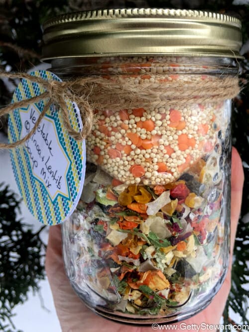 Close up of sealed vegetable quinoa soup mix in a jar with decorative label.