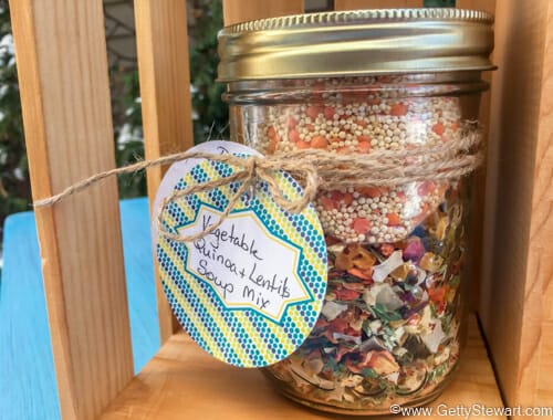 Vegetable quinoa soup mix in a jar with decorative gift label