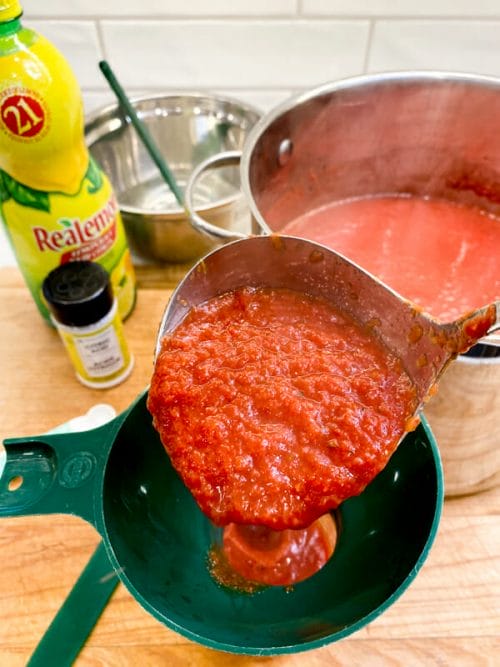 filling jar of tomato sauce lemon juice & citric acid on side