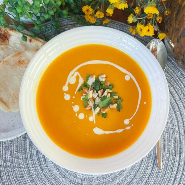 butternut squash soup in bowl with cashews and cilantro