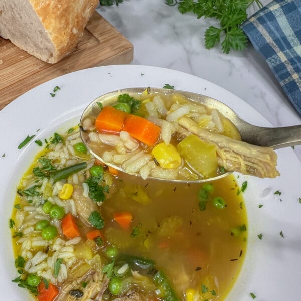 chicken rice soup on spoon with veggies and chicken