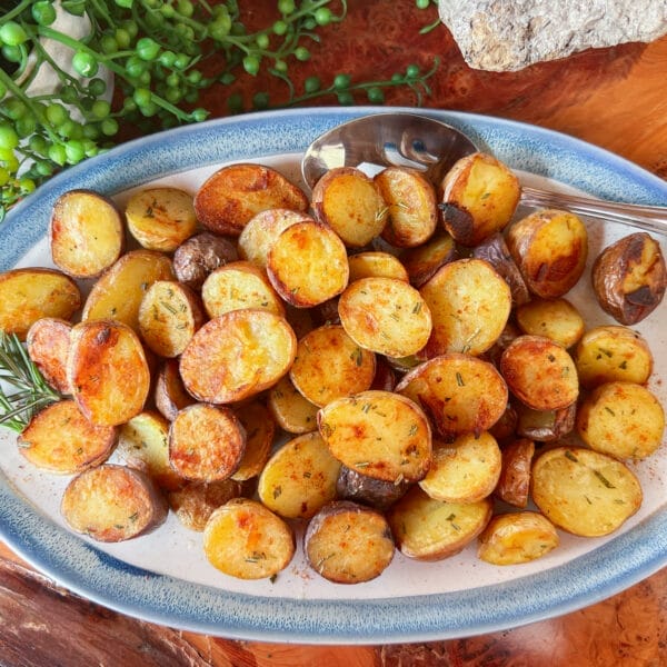 golden crispy roasted potatoes with rosemary on platter
