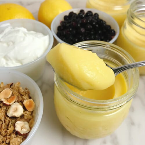 lemon curd on spoon over jar
