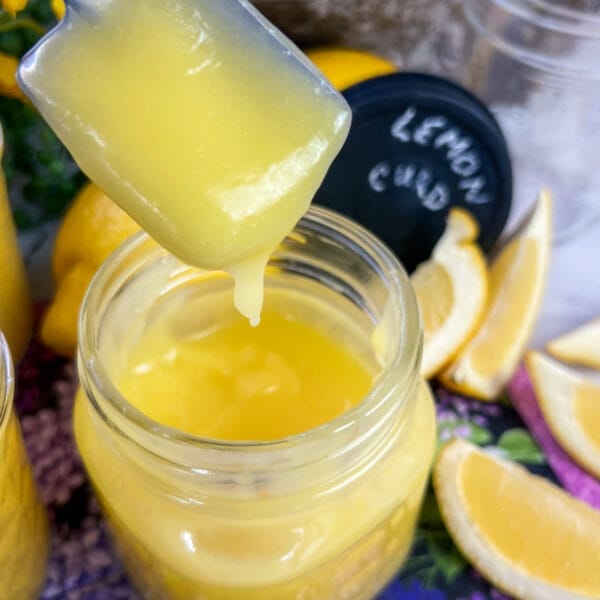 lemon curd on spoon over jar