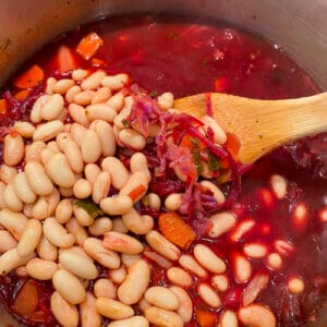 adding beans to pot of borscht