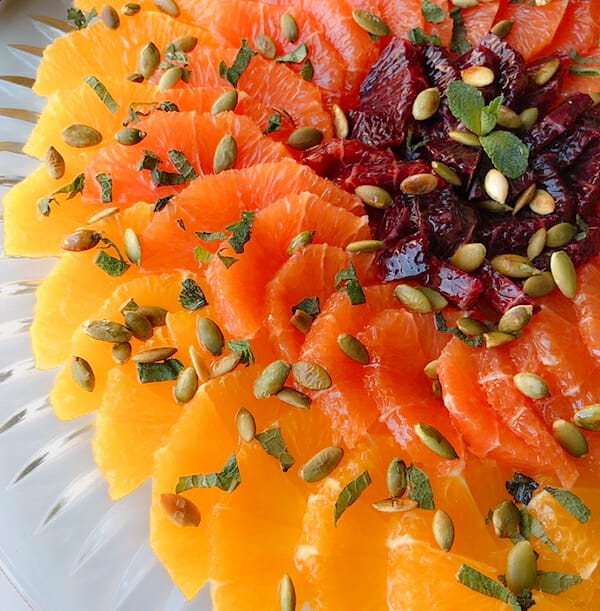 orange and mint salad arranged in rounds with 3 colors and topped with toasted pepitas