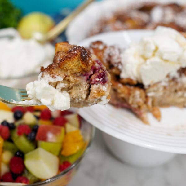 apple cranberry French toast bake with whipped cream on fork