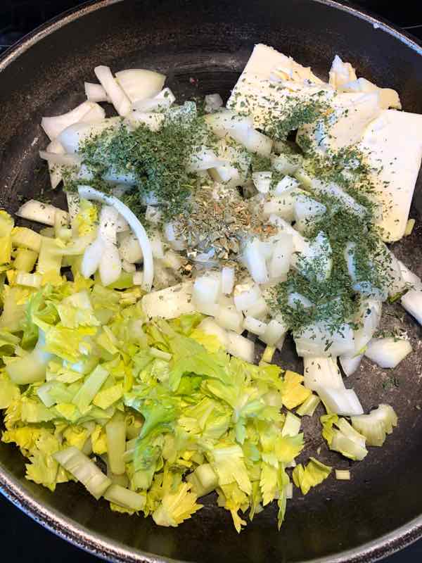 celery, onion, butter, herbs in pan ready to saute