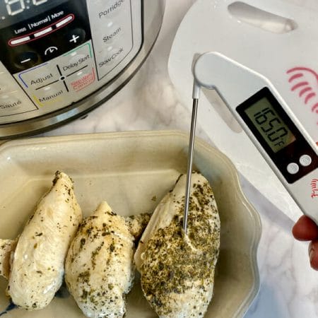 Checking chicken with internal thermometer that reads 165F