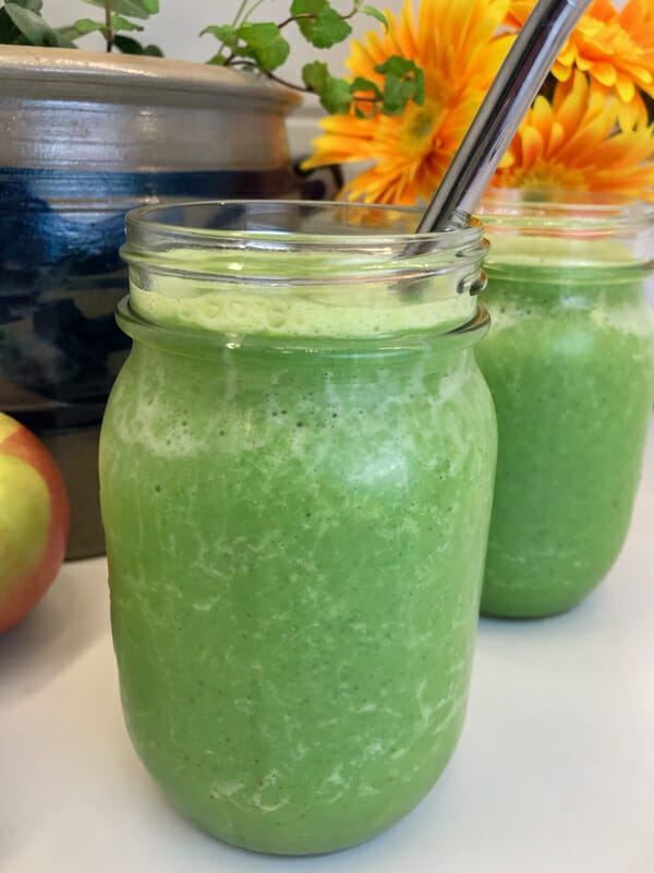 kale smoothie in glass with metal straw