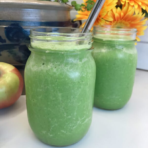 kale smoothie in glass with straw