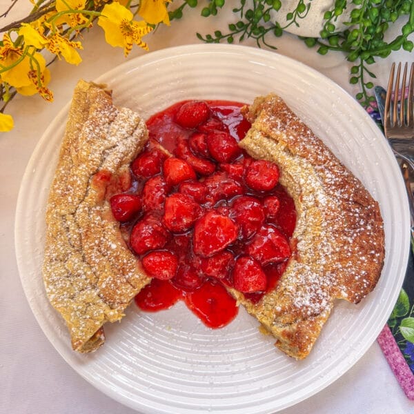 strawberry sauce on puffed pancake on plate