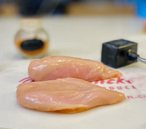 raw chicken breasts on cutting board