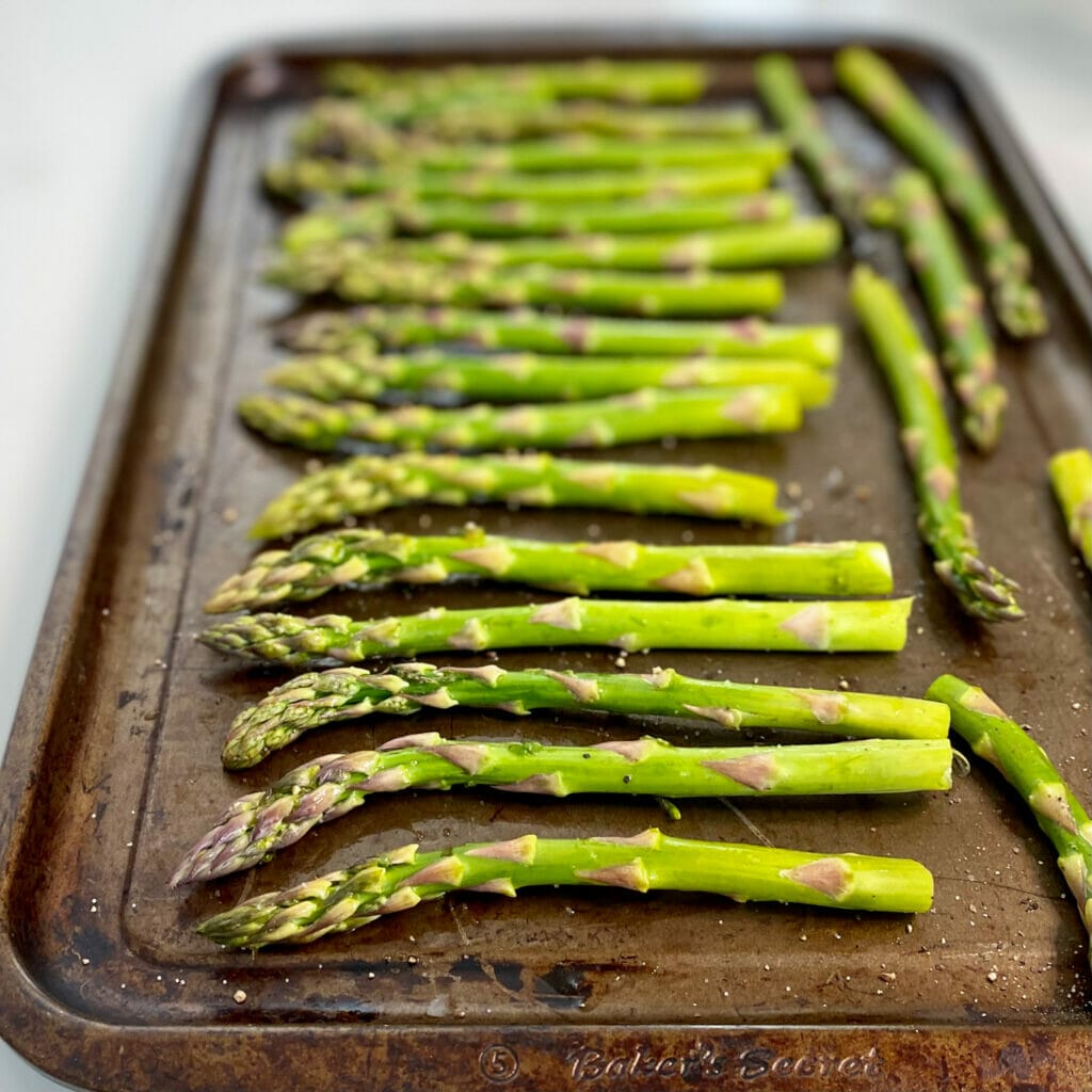 asparagus laid on baking sheet ready for oven