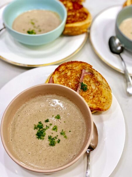 bowl of mushroom soup with grilled cheese sandwich on side
