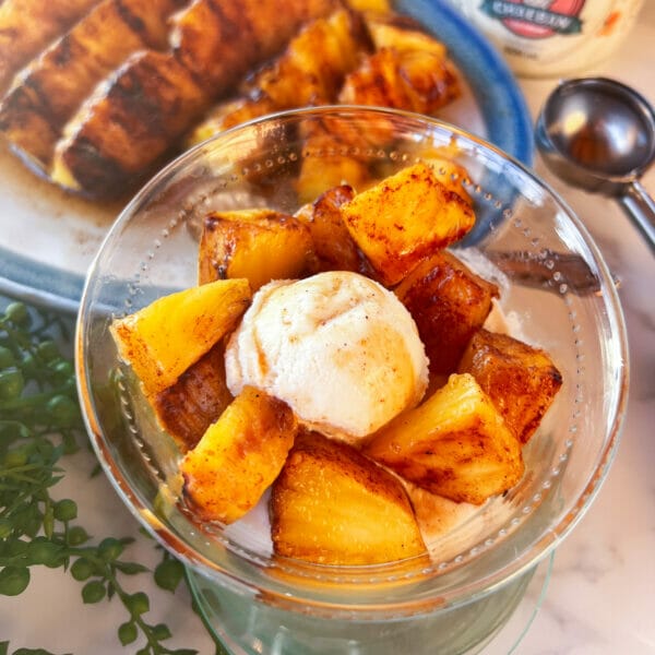 pieces of grilled pineapple in bowl with ice cream