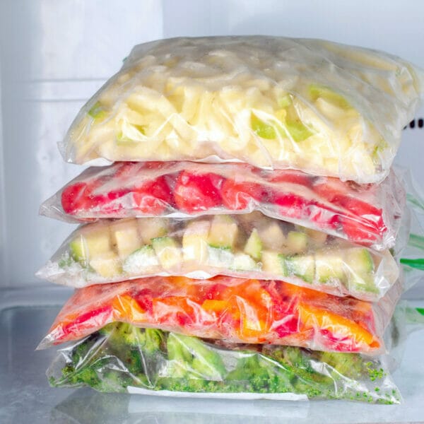 stack of 5 bags of frozen veggies: squash, tomatoes, zucchini, peppers and broccoli