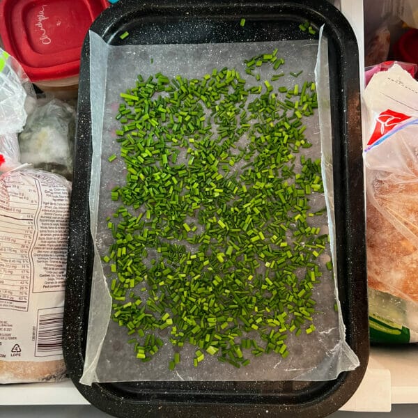 chopped chives on wax paper tray in freezer