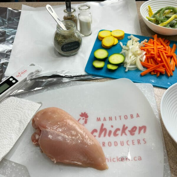 raw chicken breast with ingredients on cutting board