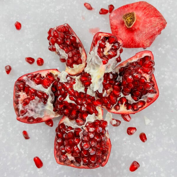 pomegranate split open into segments exposing seeds inside