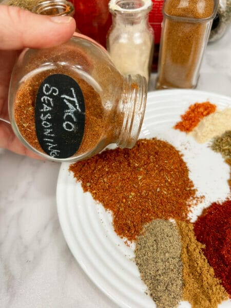 pouring taco seasoning from jar onto plate