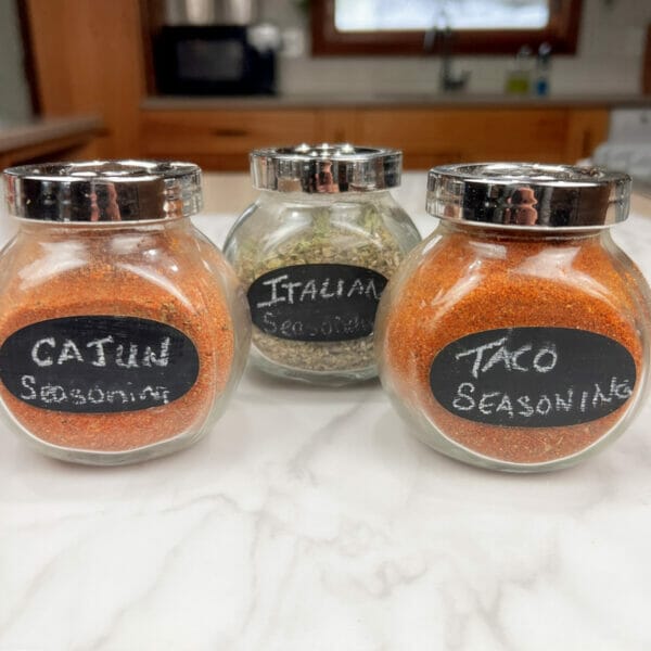 three jars of seasoning blends Cajun, Italian and Taco