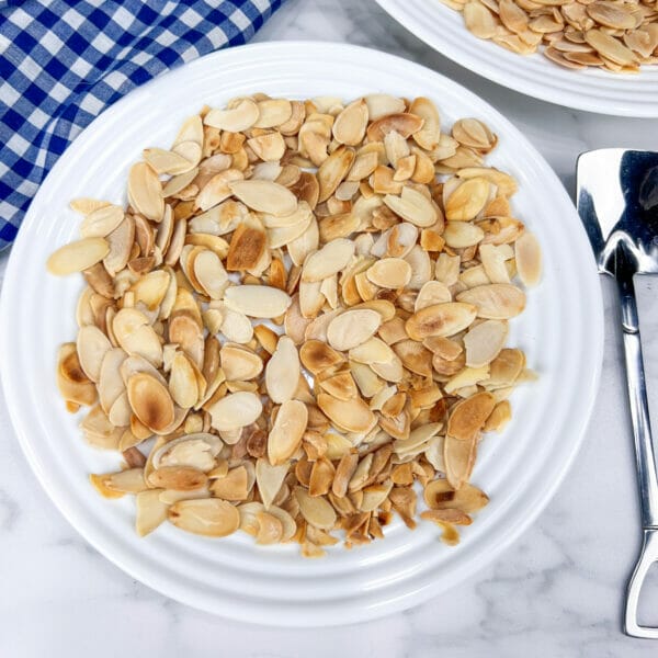unevenly toasted almond slices on small plate, some darker than others
