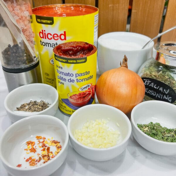 ingredients for tomato sauce in pinching bowls on counter
