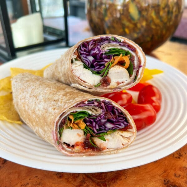 whole wheat wrap with cream cheese, cranberry sauce, shredded carrots, spinach, red cabbage.
