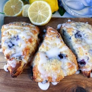 blueberry lemon scones on board with lemon glaze