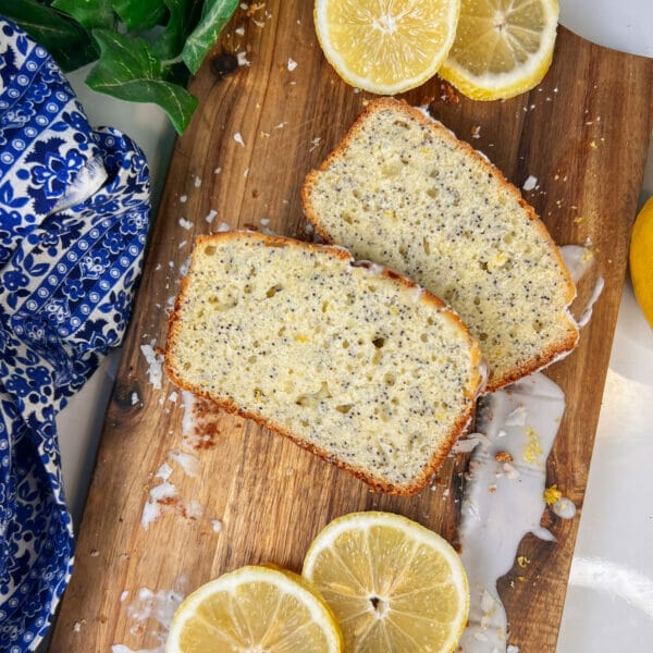 lemon poppyseed loaf slices on cutting board with lemons